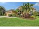 Tan house with palm trees and well-manicured landscaping at 6476 Royal Tern Cir, Lakewood Ranch, FL 34202