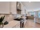 Modern kitchen with white cabinets, gas range, and a marble countertop at 6476 Royal Tern Cir, Lakewood Ranch, FL 34202