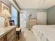 Bright bedroom with ensuite bath access, featuring a dresser and desk at 6609 Stone River Rd # 104, Bradenton, FL 34203