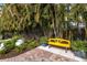 Landscaped backyard with yellow bench and lush greenery at 1923 Hibiscus St, Sarasota, FL 34239