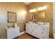 Modern bathroom with double sinks, gold wallpaper, and white vanity at 1923 Hibiscus St, Sarasota, FL 34239