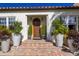 Inviting entryway with a wood door, brick steps, and large planters at 1923 Hibiscus St, Sarasota, FL 34239