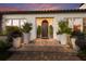 Elegant entryway with a wood door and large planters at night at 1923 Hibiscus St, Sarasota, FL 34239