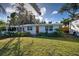 Bright white house with orange door and palm trees at 315 Palmetto W Rd, Nokomis, FL 34275