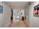 Long hallway with barn doors and terracotta tile floors at 315 Palmetto W Rd, Nokomis, FL 34275