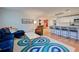 Bright living room with blue sofa, terracotta tile floors, and a large TV at 315 Palmetto W Rd, Nokomis, FL 34275