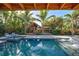 Relaxing pool area with tiki hut, spa, and comfortable lounge chairs at 315 Palmetto W Rd, Nokomis, FL 34275