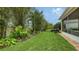 Landscaped backyard with lush greenery and grassy lawn at 3625 Tin Cup Blvd, Sarasota, FL 34232