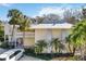 Condo building with a metal roof and white exterior, featuring tropical landscaping at 5310 Gulf Of Mexico Dr # 11, Longboat Key, FL 34228