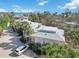 Exterior view of a charming condo building with metal roof and tropical landscaping at 5310 Gulf Of Mexico Dr # 11, Longboat Key, FL 34228