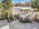 View of condo building's exterior, showing the entrance and surrounding vegetation at 5310 Gulf Of Mexico Dr # 11, Longboat Key, FL 34228