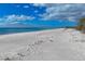 Wide, sandy beach with clear water and blue sky at 5965 Gulf Of Mexico Dr, Longboat Key, FL 34228