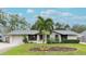 Attractive single-story home with gray and white exterior, landscaping, and a palm tree at 6201 34Th W Ave, Bradenton, FL 34209