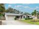 Single-story home with attached garage, mature landscaping, and a palm tree at 6201 34Th W Ave, Bradenton, FL 34209