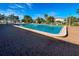 Community pool surrounded by a brick paved deck and tropical foliage at 6824 Haawi Ct, North Port, FL 34287