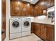 Laundry room with white washer and dryer and dark wood cabinets at 749 Freeling Dr, Sarasota, FL 34242