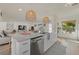 Open kitchen with white cabinets, island, and modern lighting at 2069 Bougainvillea St, Sarasota, FL 34239