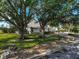 White, one-story home nestled among mature trees and lush landscaping at 3970 Prairie Dunes Dr, Sarasota, FL 34238