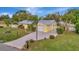 Attractive yellow house with gray metal roof, driveway, and landscaped yard at 409 Archibald Ave, Sarasota, FL 34243