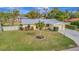 Cute yellow house with gray metal roof, white fence, and spacious lawn at 409 Archibald Ave, Sarasota, FL 34243