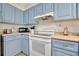 Updated kitchen with light blue cabinets and white appliances at 409 Archibald Ave, Sarasota, FL 34243