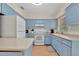 Updated kitchen with light blue cabinets, white appliances, and light countertops at 409 Archibald Ave, Sarasota, FL 34243