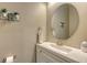 Small bathroom with a round mirror, white vanity, and modern fixtures at 4730 Zeno Ct, Bradenton, FL 34211