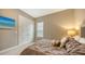 Bright bedroom with a queen bed, window blinds, and double doors at 4730 Zeno Ct, Bradenton, FL 34211