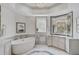Elegant bathroom features a freestanding tub, marble flooring, and large vanity at 85 Sugar Mill Dr, Osprey, FL 34229