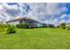 Landscaped backyard, showcasing home's exterior and screened lanai at 12735 Aquamarine Ave, Bradenton, FL 34211