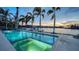 Beautiful waterfront pool with palm trees, boat dock, and sunset views at 1430 Harbor Dr, Sarasota, FL 34239