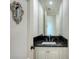 Modern powder room features a black marble vanity and white cabinetry at 1430 Harbor Dr, Sarasota, FL 34239