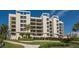 Modern condo building with manicured landscaping and water views at 1932 Harbourside Dr # 232, Longboat Key, FL 34228