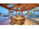 Elegant covered patio with water views, dining furniture, and a ceiling fan at 50 Lighthouse Point Dr, Longboat Key, FL 34228