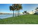 Scenic waterfront view with lush lawn and palm trees at 50 Lighthouse Point Dr, Longboat Key, FL 34228