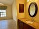 Bathroom with granite countertop, wood cabinets, and oval mirror at 5405 Fair Oaks St # 5405, Bradenton, FL 34203