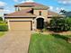 Two-story house with tan exterior, brown roof, and a two-car garage at 7926 111Th E Ter, Parrish, FL 34219