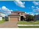 Two-story house with tan exterior, brown roof, and a two-car garage at 7926 111Th E Ter, Parrish, FL 34219