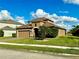 Two-story house with tan exterior, brown roof, and a two-car garage at 7926 111Th E Ter, Parrish, FL 34219