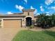 Two-story house with tan exterior, brown roof, and a two-car garage at 7926 111Th E Ter, Parrish, FL 34219