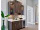 Modern wet bar with dark cabinetry, quartz countertops, and wine cooler at 8372 Sea Glass Ct, Sarasota, FL 34240