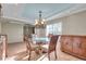 Bright dining room with glass table, chandelier, and hardwood floors at 9393 Midnight Pass Rd # 201, Sarasota, FL 34242