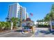 Gated entrance to community with signage and American flag at 9393 Midnight Pass Rd # 201, Sarasota, FL 34242