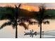 Sunset view over calm water with boat at 9393 Midnight Pass Rd # 201, Sarasota, FL 34242