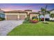 Tan two-story house with two-car garage, landscaping, and palm trees at 13325 Indigo Way, Bradenton, FL 34211