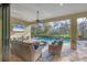 Relaxing screened-in pool area with wicker furniture and a large TV at 13325 Indigo Way, Bradenton, FL 34211