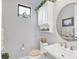 Elegant powder room with white vanity, toilet and decorative mirror at 13325 Indigo Way, Bradenton, FL 34211