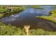 Fishing pier on a calm body of water, surrounded by lush vegetation at 608 Misty Pond Ct, Bradenton, FL 34212