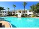 Inviting resort-style pool with palm trees and building in background at 6440 Mourning Dove Dr # 403, Bradenton, FL 34210