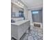 Bathroom with gray vanity, marble countertop, and patterned floor at 6609 Waterford Ln, Sarasota, FL 34238